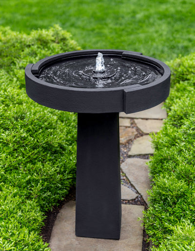 Black birdbath fountain with contemporary open bowl on stone walk