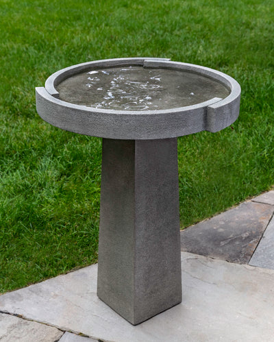 Round  bowl birdbath with angular stand filled with water