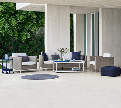 Deep seating set on white terrace in front of modern house
