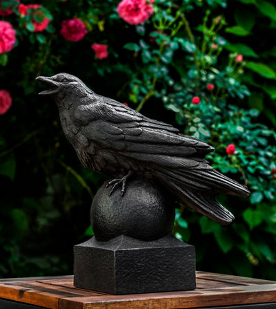 One black crow sitting on top of a finial