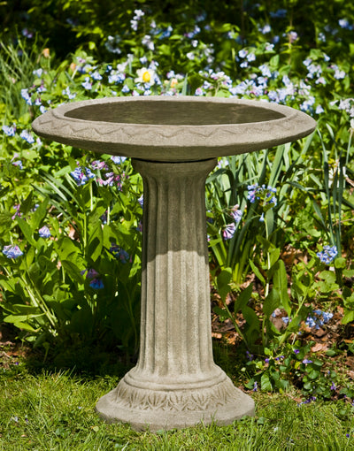 Gray birdbath with ridged stand filled with water