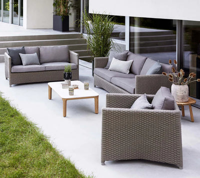 Outdoor seating set on white patio next to a lawn