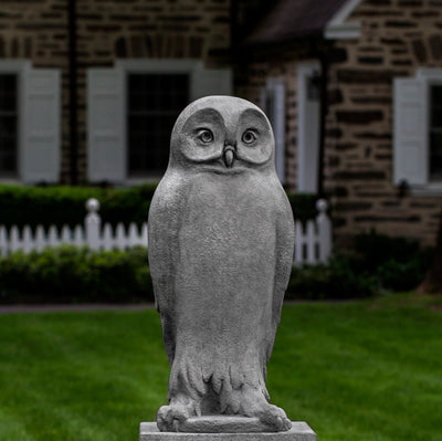 Light gray owl standing on a pedestal