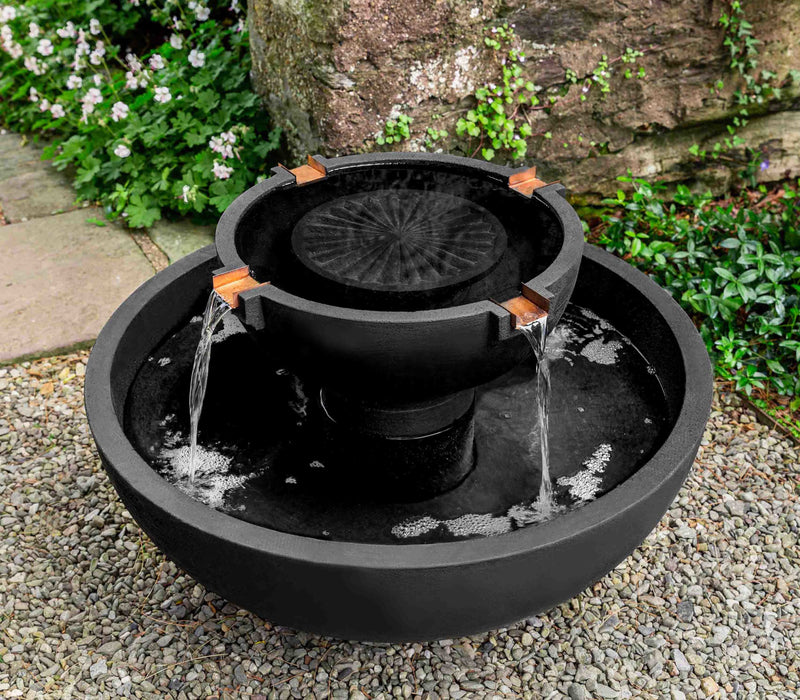 Campania International 29" Del Rey Fountain, pictured on gravel. Four copper spouts spill out of upper bowl into lower bowl.