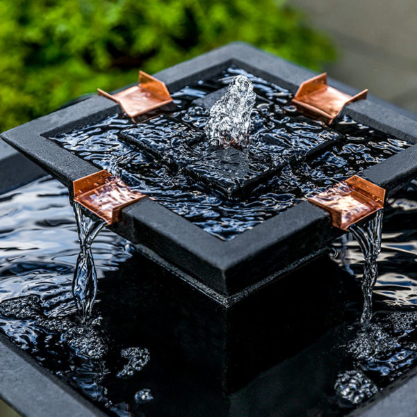 Detail picture of the top square bowl with water flowing out of copper spout