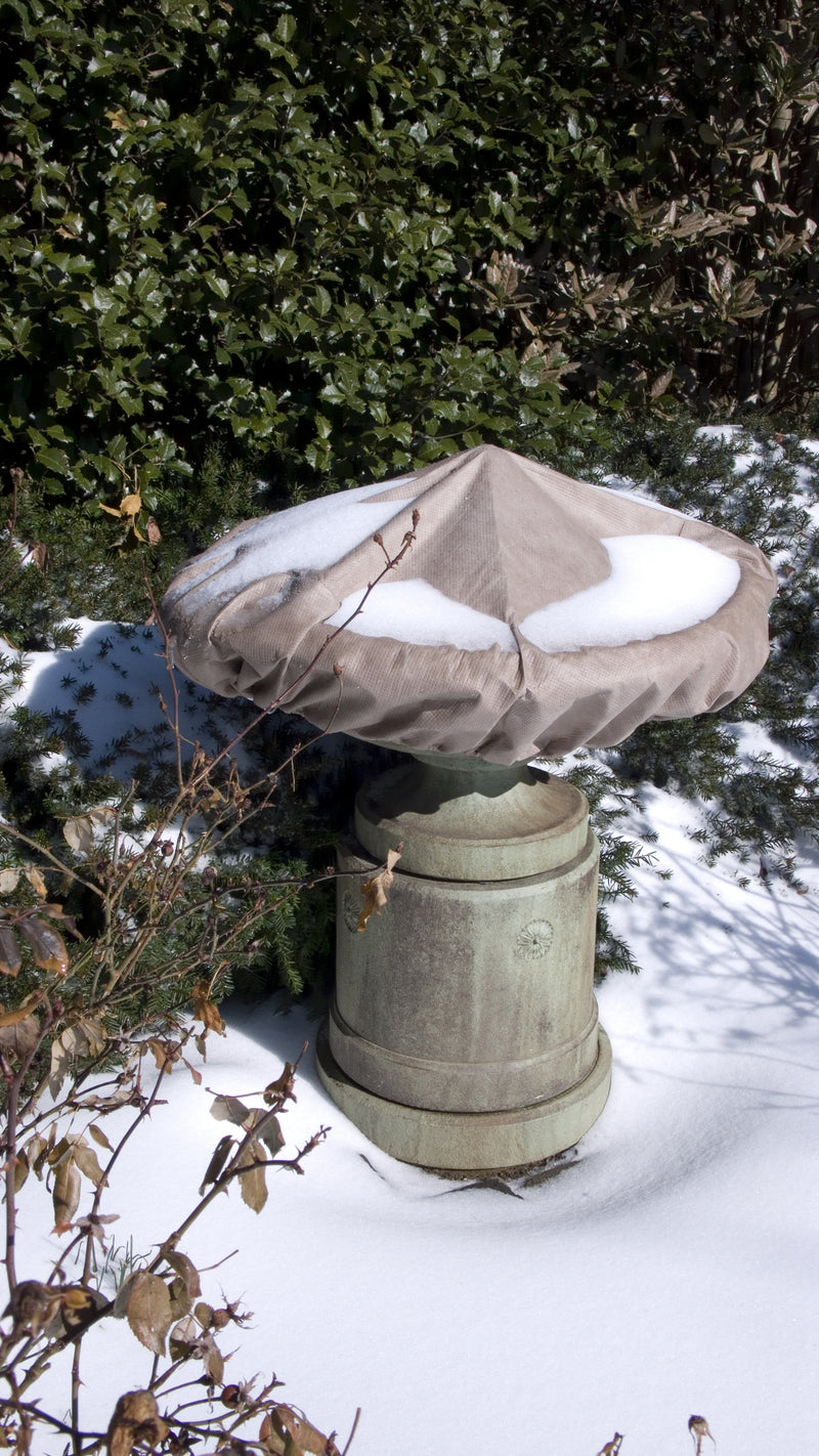 Winter scene with a taupe cover over a fountain.