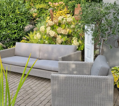 Deep seating set shown in front of yellow flowering shrub