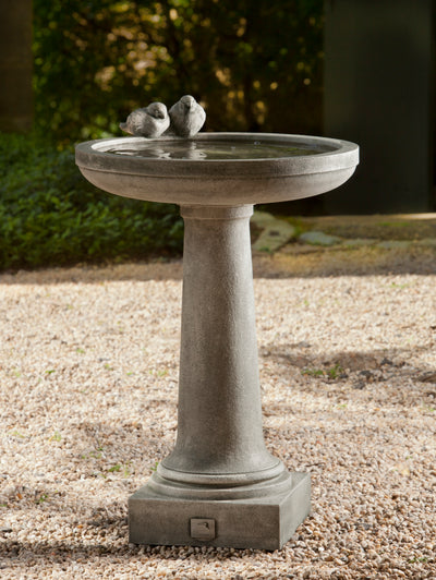 Gray birdbath with two concrete birds standing on ledge