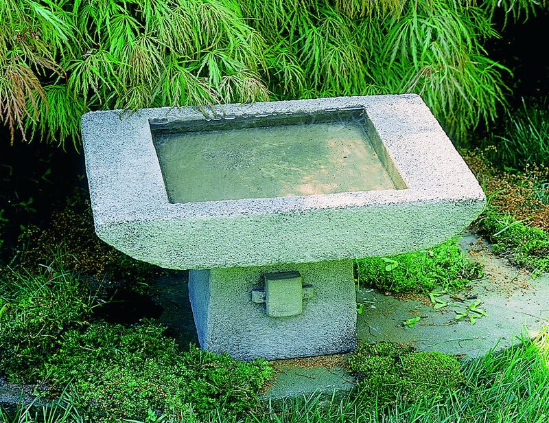 Square low gray birdbath, Asia inspired in front of bamboo