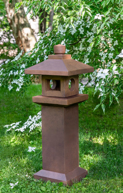 Tall pagoda in brown finish in front of tree