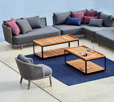 Gray outdoor sitting set with two coffee tables on blue rug
