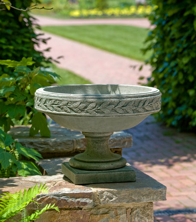 Laurel banded urn shown on stone wall