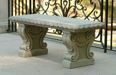 Straight bench top with decorative legs pictured in front of ornamental ironwork