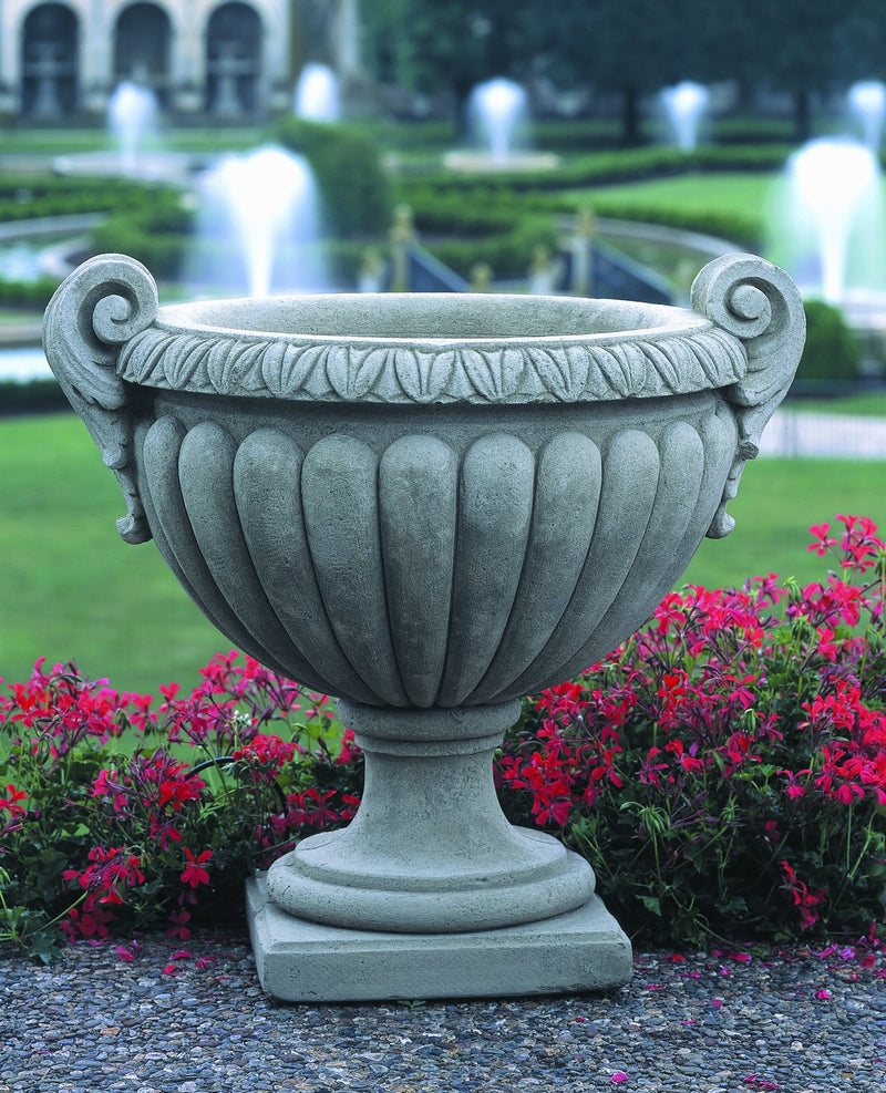 Volute handle urn shown in front of garden fountains