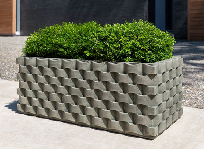 Rectangular container with weave design and planted with boxwoods