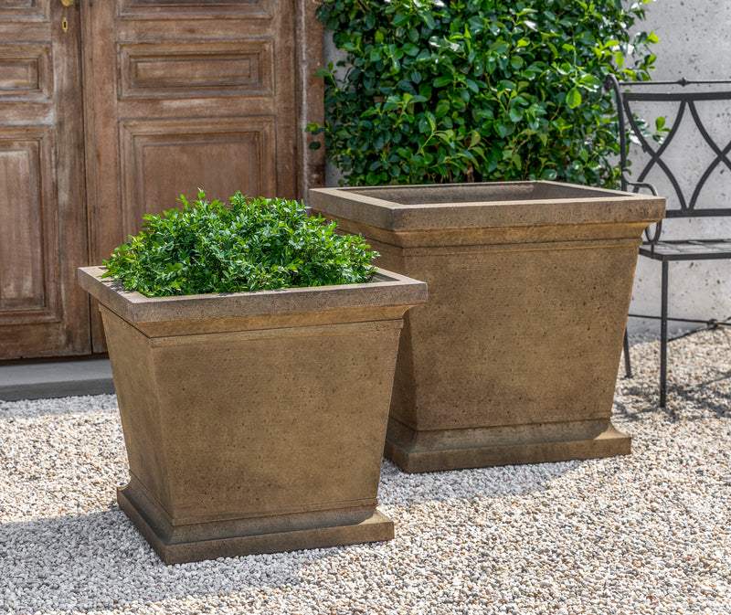 Set of 2 brown square containers shown on gravel  floor