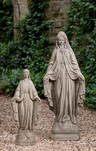 Two madonnas, one large and one small, standing on gravel