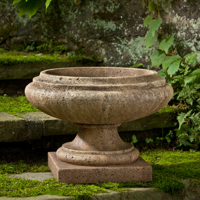 Light brown urn shown on mossy steps