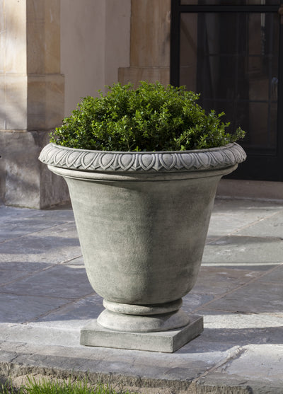 Tall grey urn planted with a boxwood