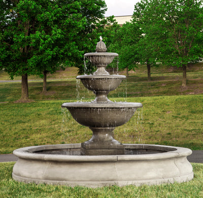 Three tiered fountain with large bowls shown running in front of hillside
