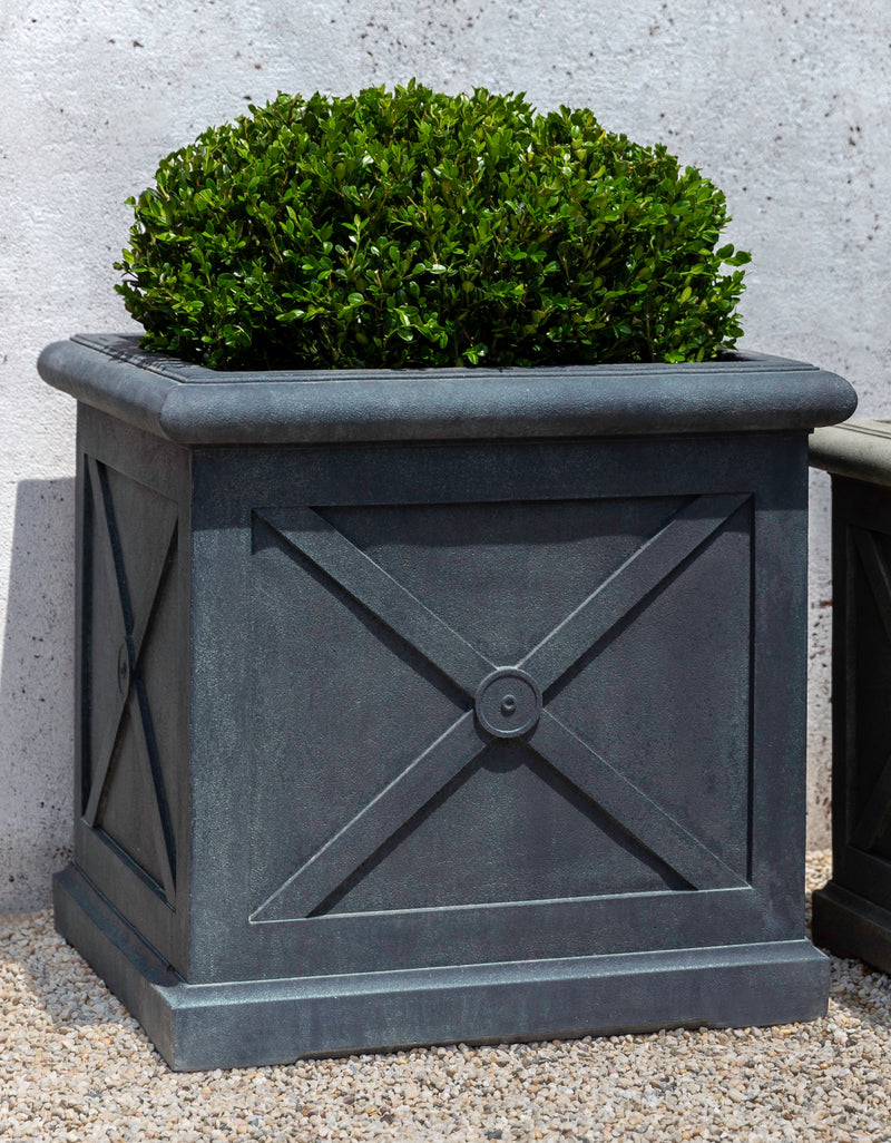 Square grey container planted with a boxwood on top pf gravel