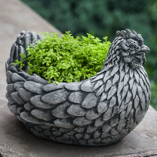 Chicken shaped container shown planted with a fern on top of a wall