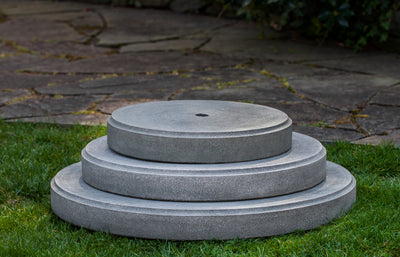 Three round plinths stacked on lawn