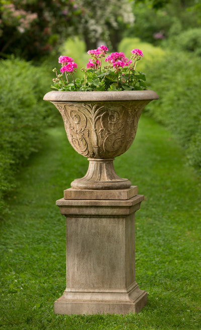 Square pedestal shown with a classic urn planted with pink geraniums