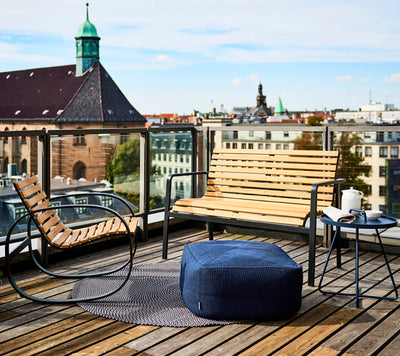 Outdoor furniture set shown on a rooftop terrace with city view in the background