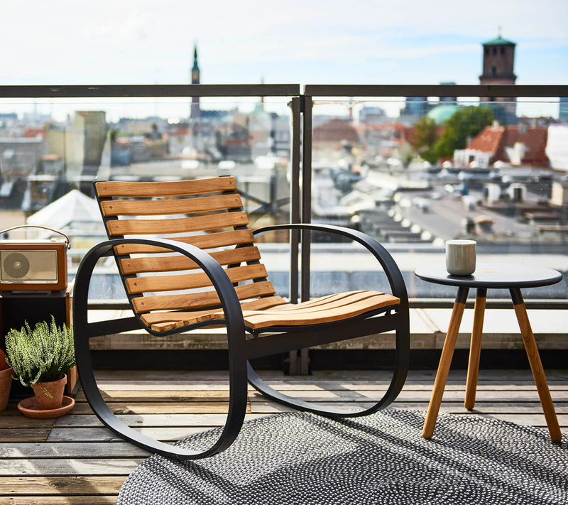 Rocking chair shown on an urban terrace with city in the background