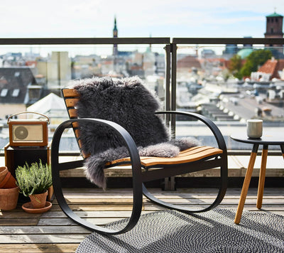 Rocking chair with fir throw on rooftop deck with city in the background