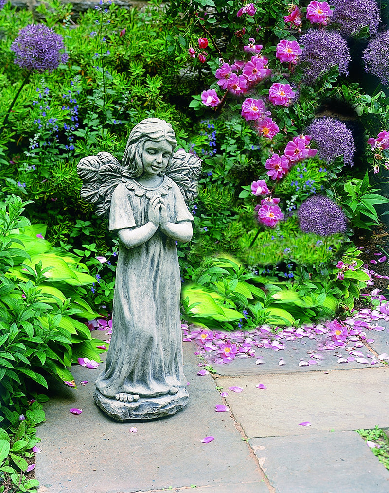 Praying angel with open wings in front of greenery