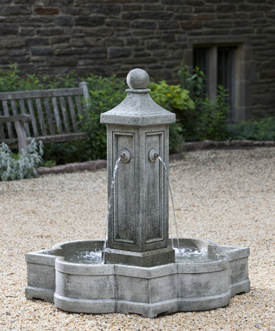 In basin fountain with four spouts on a column pictured on gravel