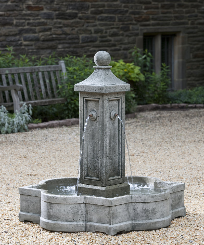 In basin fountain with four spouts on a column pictured on gravel