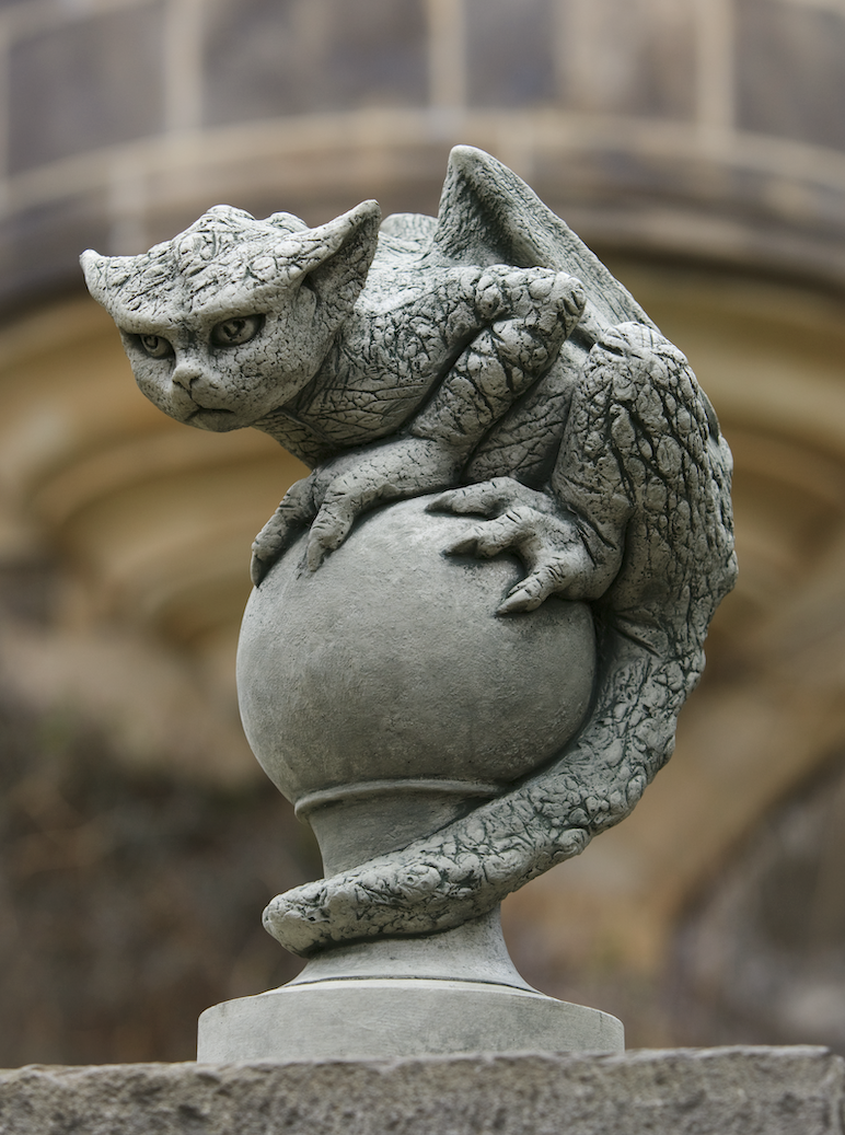 Gray dragon crouching on top of sphere