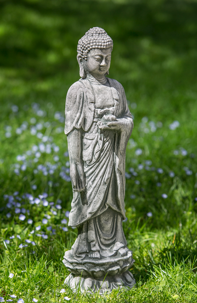 Light gray buddha standing in the grass