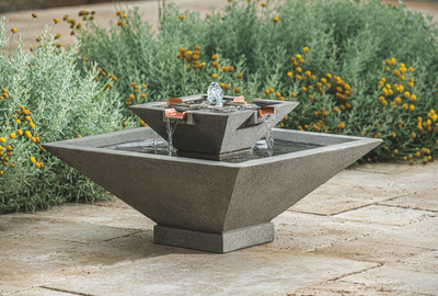 Square fountain in grey finish and copper spouts, pictured in front of perennial bed