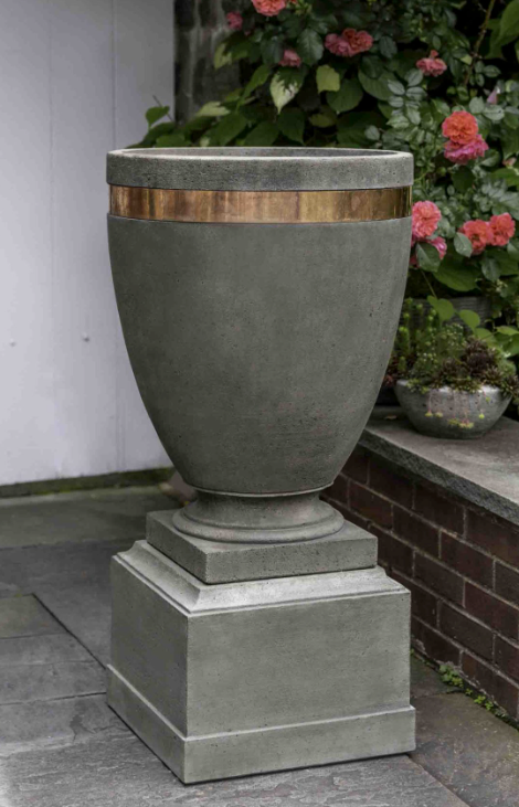 Short pedestal shown with an urn in front of roses