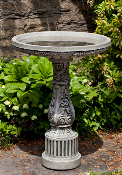 Round birdbath with adorned pedestal