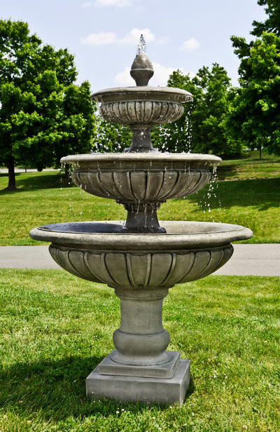 Three tiered fountain with round bowls pictured on grass
