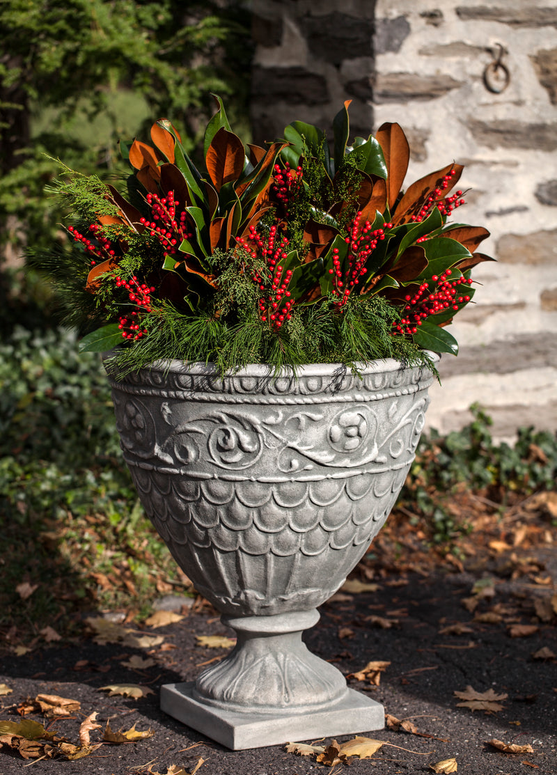 Ornate urn filled with winter berries and fresh greens