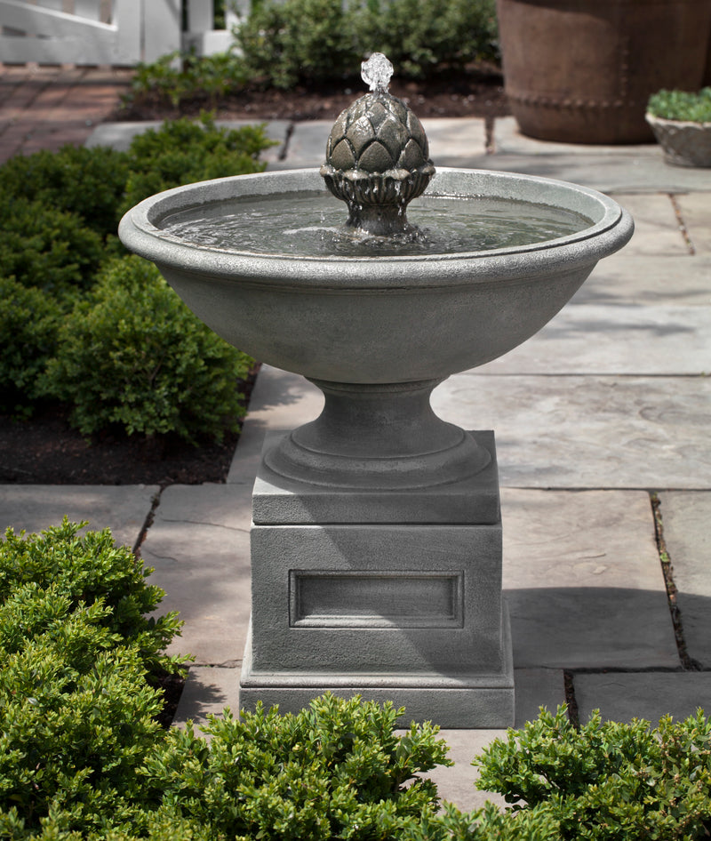 Round bowl fountain with finial in the center on top of square pedestal