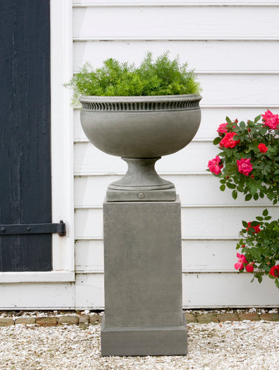 Classic urn shown planted with greenery and standing on a pedestal