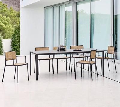 Dining set with black table and five chairs shown in front of glass  wall