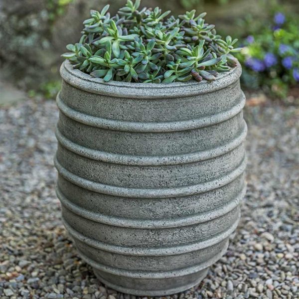 Ribbed container planted with succulents on gravel floor