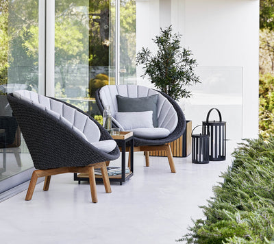 Two armchairs shown in front of glass doors on a white patio