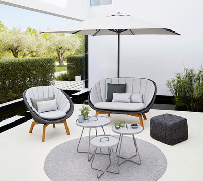 Outdoor  sofa, armchair and coffee  tables shown under a white umbrella