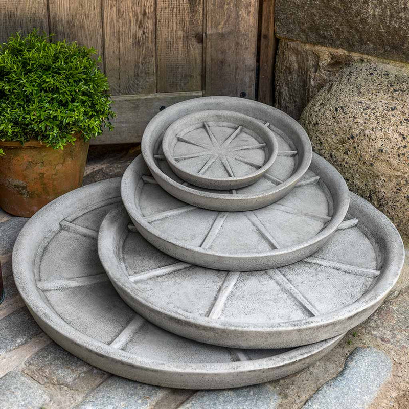 5 cast stone round saucers from extra large to extra small shown in front of wooden door