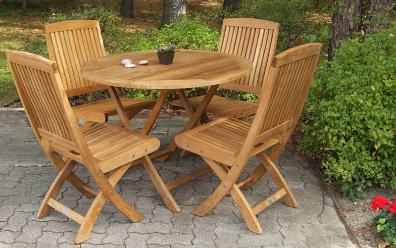 Teak dining set with round table and four chairs on a paver patio
