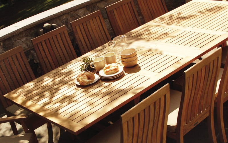 Long rectangular teak table shown with breakfast on top